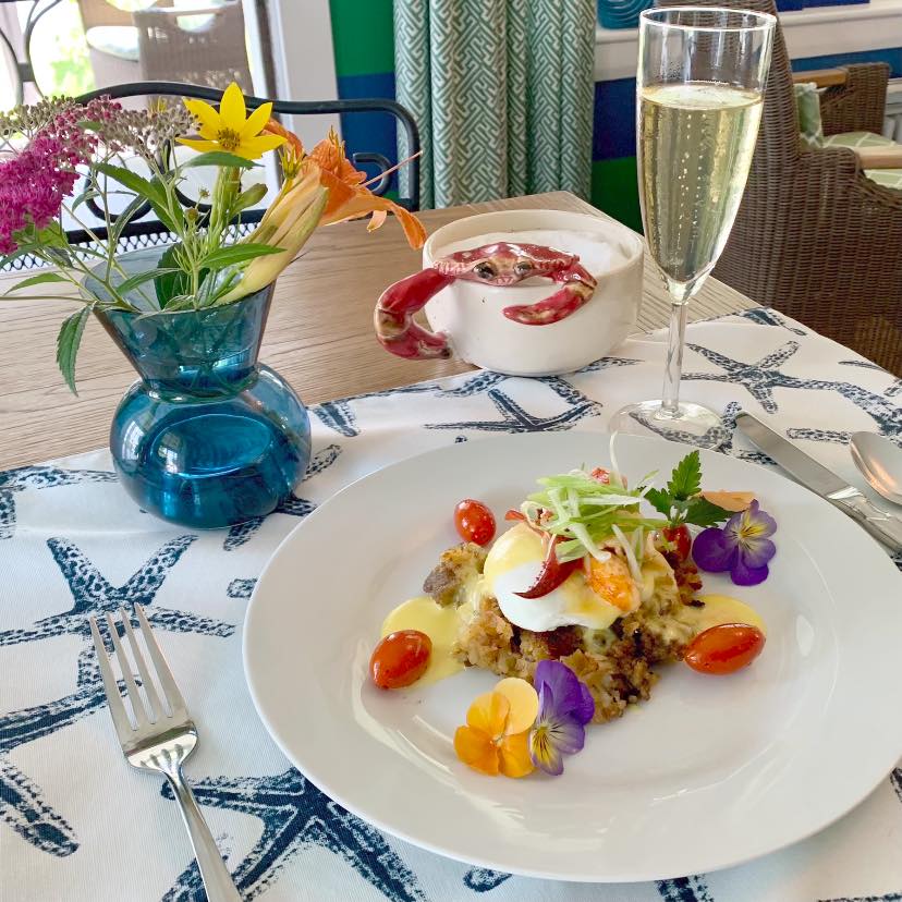 Delicious meal of lobster and sausage hash Benedict with roasted tomatoes.