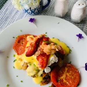 Savory lobster and sausage hash Benedict with herb roasted tomato.