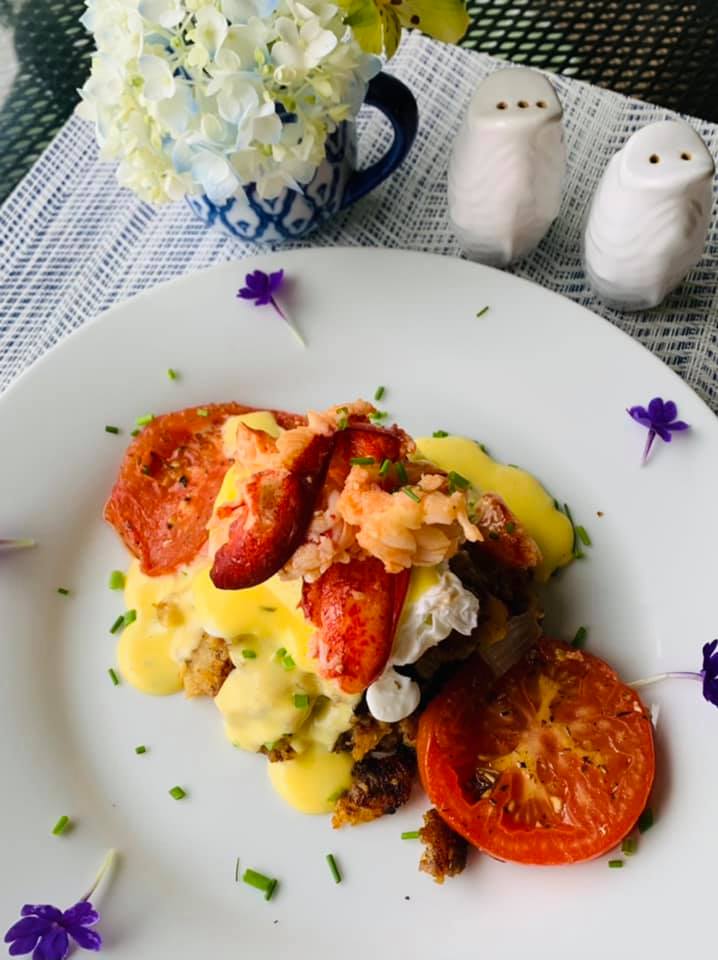 Savory lobster and sausage hash Benedict with herb roasted tomato.